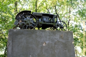 Старинный трактор на постаменте в парке